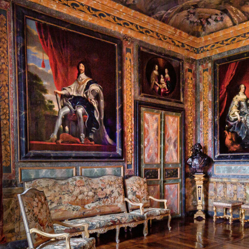 alt="Salon d’Honneur du Château de Balleroy avec murs peints en trompe-l'oeil imitant du marbre et tableaux anciens ''