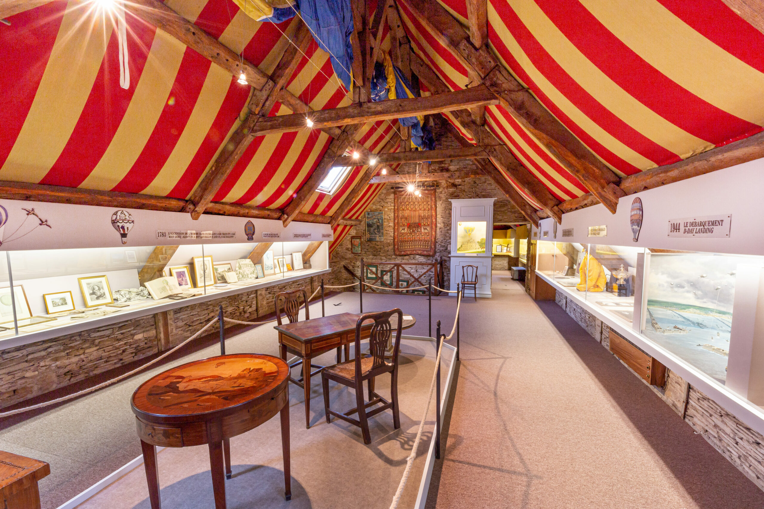 alt="Partie exposition du musée des ballons avec vitrines et maquettes"