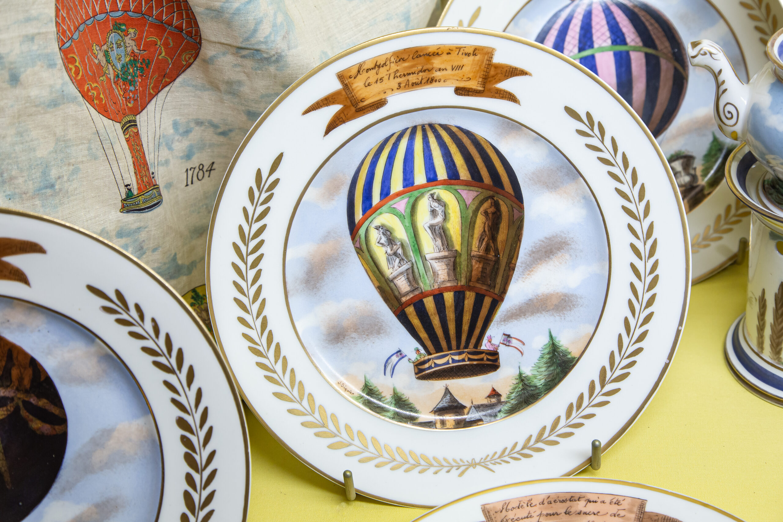 alt="Assiette en porcelaine décorée avec une montgolfière"