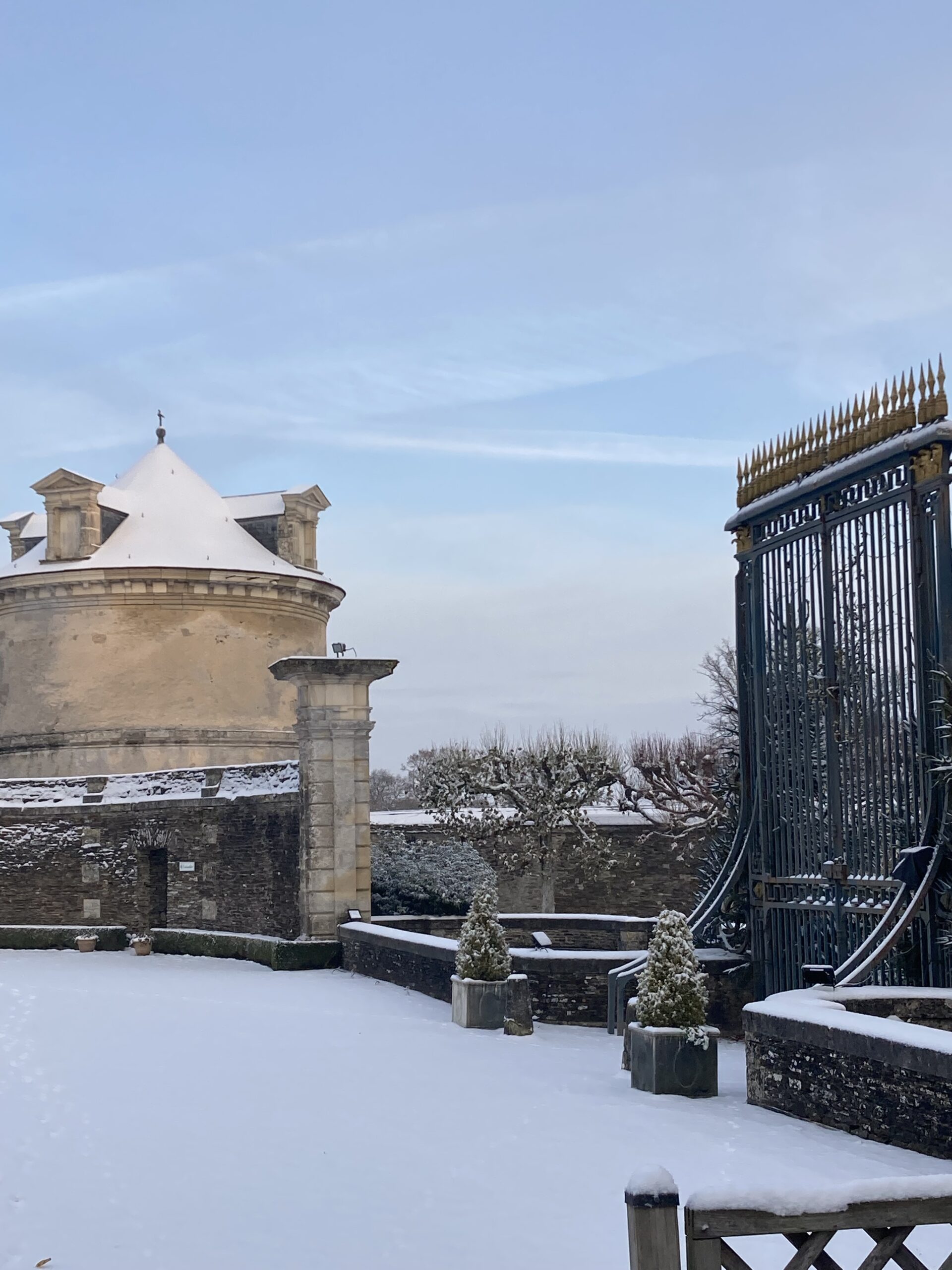 alt="Colombier du Château de Balleroy en hiver, entouré de neige."